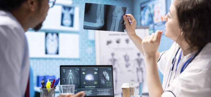 Woman physician reading x ray diagnostics for a patient in medical office Woman physician reading x ray diagnostics for a patient in medical office, doing a test results scan interpretation to help person with disease. Providing treatment and advice for recovery.