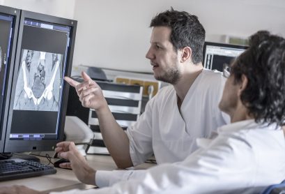 Two doctors discussing x-ray image on computer screen Two doctors discussing x-ray image on computer screen