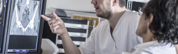 Two doctors discussing x-ray image on computer screen
